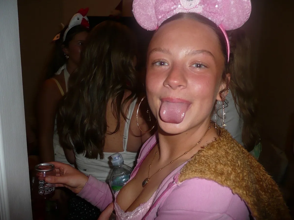 A friend in pink mouse ears pulling a face, FizzBomb can in hand