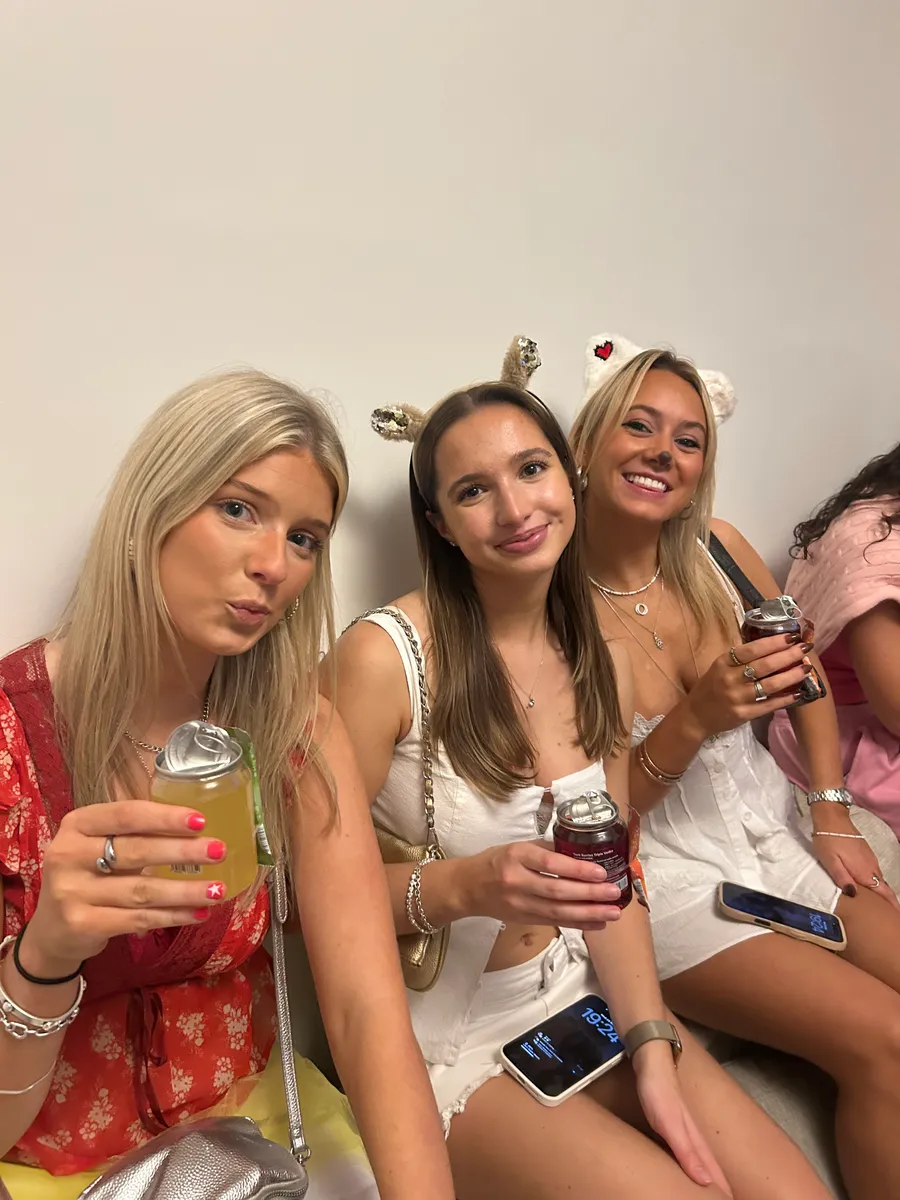 Three friends on a sofa, each holding a FizzBomb can